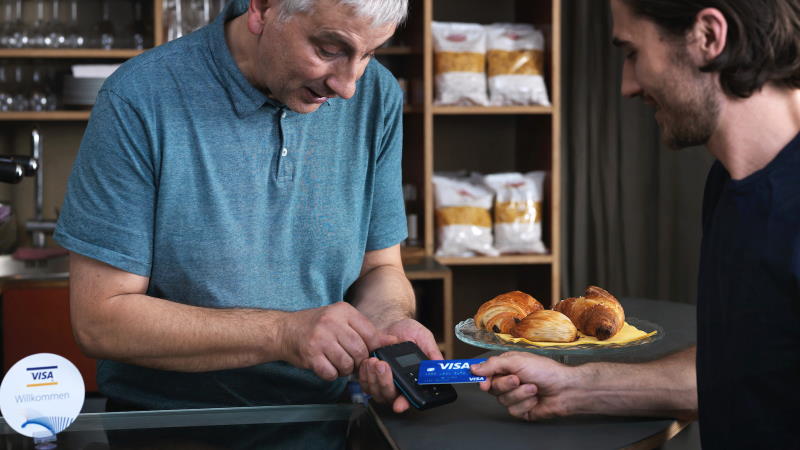 Man paying with contactless card in cafe